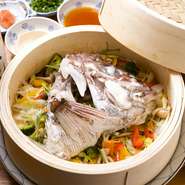 大きな天然鯛のあらをたっぷりの野菜と一緒に一気に蒸し上げ、特製のポン酢とゴマだれで。