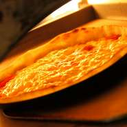 専用釜で高温で焼く薄焼きのパリッとしたピッツァ。生地は手作りクリスピータイプ。