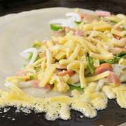 具材をのせ（チーズがはみ出るようにのせて）、クレープのように包んだら出来上がり☆イチオシメニュー参照