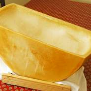 イタリアより直送のパルメザンチーズ。半切りした中にリゾットを直接入れ、チーズを溶かして仕上げます。一連の作業をスタッフがお客様の前で行なうのでパフォーマンスも同時に楽しめます。