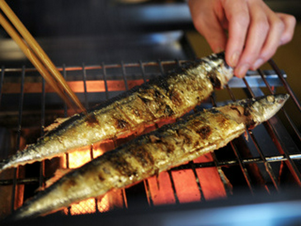 人気の居酒屋フロアにて旬のサンマを焼いて。