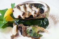 獲れたてアワビを豪快に焼き、トリュフバターソースをつけて食べる贅沢な逸品『活アワビの鉄板焼』