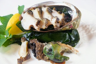 獲れたてアワビを豪快に焼き、トリュフバターソースをつけて食べる贅沢な逸品『活アワビの鉄板焼』