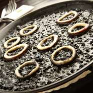 魚のアラをふんだんに使った出汁に、海老の頭、殻を炒めたエキスを加え、イカスミを混ぜたスープで炊き上げます。凝縮された魚介の旨味とイカスミのコクが米にしっかり浸透し、イカの食感も楽しい逸品。