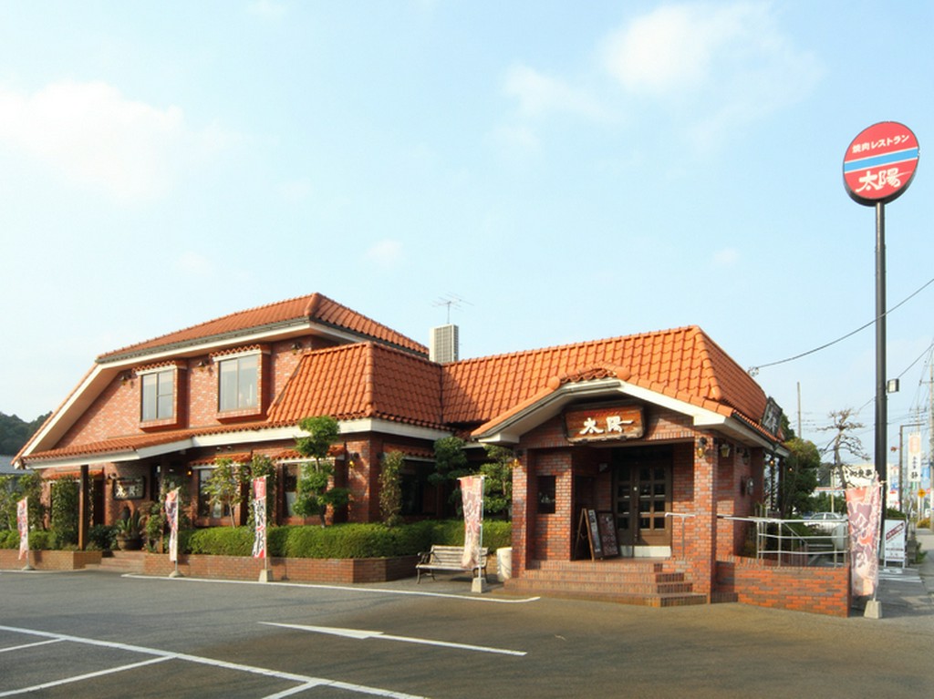 レンガ造りの建物と赤い看板が目印です