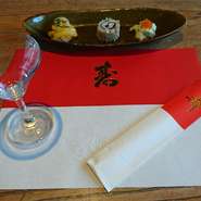コース料理はもちろん、テーブルマットや箸袋も紅白のお祝いの寿仕様になり、特別な日のおめでたい雰囲気をかもし出します。