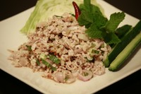 隣国ラオスの影響を大きく受けたタイ東北料理。豚挽き肉の辛酸っぱいサラダ。 味と食感のポイントに炒った米粉が使われております。一度ハマると病みつきになってしまう依存性のある魅力的な料理です。