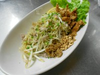 茹でた中華麺をナンプラー&ガーリックオイルで和えていますが、しつこくない油そば風の汁なし麺です。
豚挽肉とモヤシを和え、砕いた落花生、からし菜、冬菜、レモン、そして鶏皮揚げをアクセントに添えております。