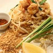 "タイを炒める"という意味のタイを代表する麺料理。 米の麺に甘酸っぱいタマリンドとココナッツシュガーを煮込んで仕上げたソースを絡め炒めて、ピーナッツやレモンとともに頂きます。 