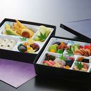 会席料理を詰め合わせたお弁当です。3.240円（一段）、5.940円（二段）のご予算でお承り致します。内容は仕入れと季節により変更致します。またアレルギー対応も致します。二日前までのご予約が必要です。