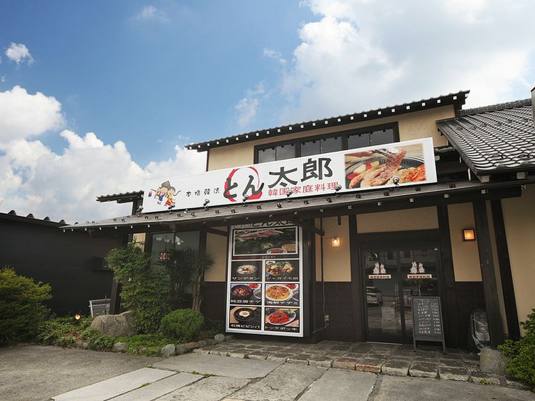 大きな看板が目印。緑の庭と趣ある古民家がお迎えします