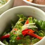 女性客にも好評なミニサラダ。特製のドレッシングをかけています。