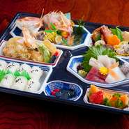 お祝い事には、やはり鯛は欠かせません。小鯛は三枚におろして骨抜きをしてたべやすくしております。見ているだけで華やかな気分になれるように彩りよく。
小鯛、お造り、天婦羅、煮物、フルーツ、白米or赤飯が。