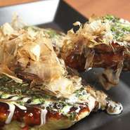 豚肉、餅、チーズ、レンコン、具だくさんのお好み焼き。トロトロでサクサクの食感をご賞味ください。