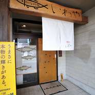 看板やガラス窓の、お魚のマークがかわいいナチュラルな雰囲気の外観。店内、座敷はもちろんリラックスできますが、カウンター席も調理スペースを囲んで円形になっているので、オーナーとの会話も楽しめます。