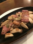 ベーコンの旨味をまとったプリプリえりんぎ
を熱々の鉄板で提供。