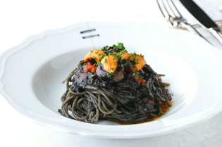 濃厚なトマトソースがリッチな『イカスミのパスタ生雲丹添え』