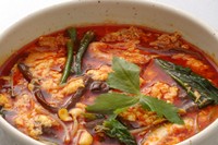 鶏ガラをじっくり煮込んだスープに赤唐辛子をふんだんに入れた辛口雑炊。
