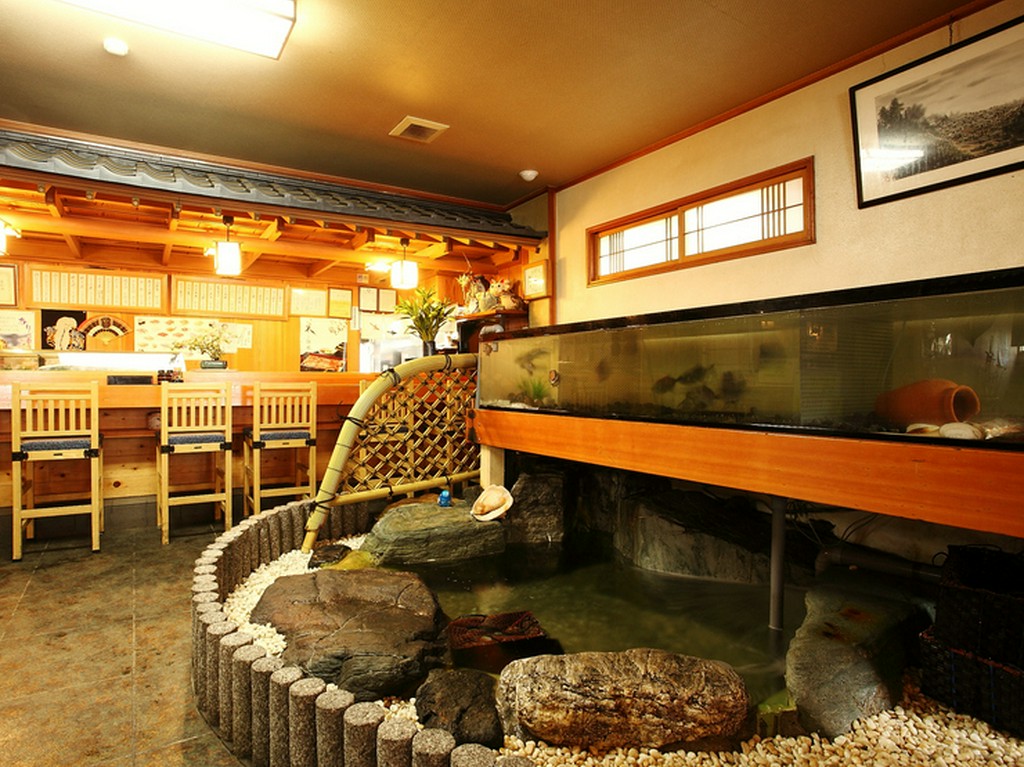 活魚が泳ぐ大型いけすのある店内