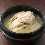鶏丸ごと入って、餅米、ナツメ、朝鮮人参など薬膳具材たっぷり。長時間煮込んだコクのある塩味スープ