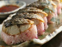 脂ののったサバの大トロに炙りを入れ、しば漬け・ごま等を合わせた酢飯で棒寿司に。見目も鮮やかな一品。