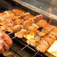 全長21センチほどあるジャンボな豚バラ串は、食べ応えたっぷり！　ジューシーな味わいをじっくりと満喫できます。備長炭を使用し、絶妙の焼き加減でお召し上がりいただけます。