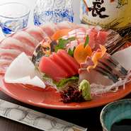 料亭で修行を積んだ店主が選んだ素材と器に注目したいメニューです。（写真は生鮪・縞鯵・鯛うす造り）