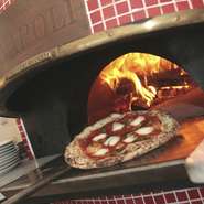 お店で提供しているピッツァは、イタリア　ナポリから取り寄せた薪窯を使い、薪で焼き上げています。その日の気温や湿度により、火加減を調節しながら焼き上げたピッツァは、味はもちろんのこと、風味も抜群です。