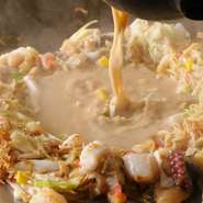 豚・イカ・タコ・帆立・エビ・コーン・紅生姜・卵・麩と具沢山の一品！　素材の味がスープに溶け出し
至高のもんじゃになります