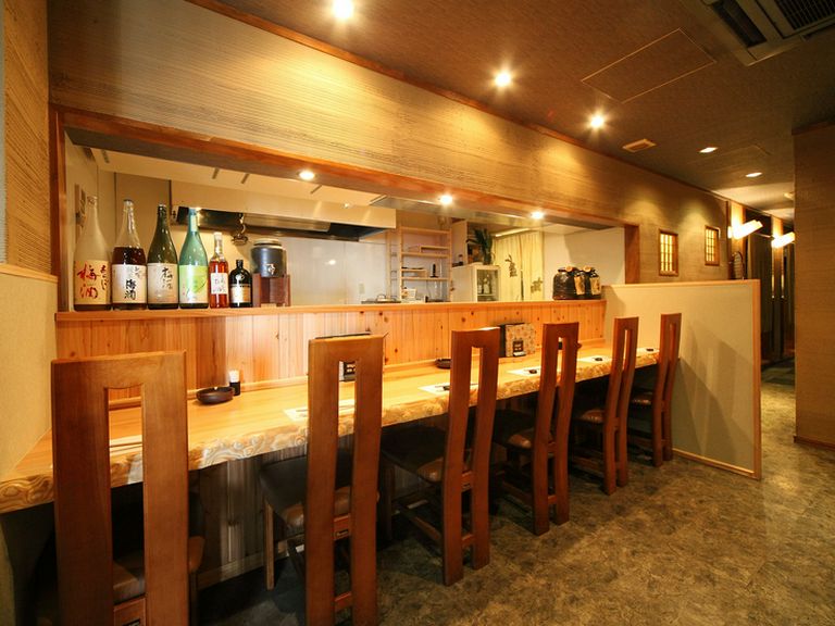 大きな一枚板テーブルの、ゆったりとしたカウンター席