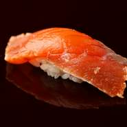 青森県産の鱒の握り。脂ののった肉質を生かすため、皮目を炙り、香ばしさを際立たせてからづけにしました。