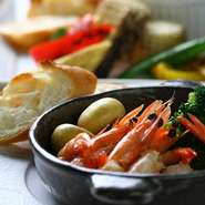 大きなエビが丸ごと入っており、季節野菜をふんだんに使った具だくさんのピリ辛アヒージョです。