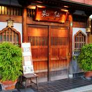 日比谷線「六本木駅」から徒歩1分。都会の喧騒の中、禅寺風の門構えで古鎌倉の雰囲気を漂わせる【串喝　知仙】は、食材にこだわり抜いた日本料理店です。今宵の料理に胸躍らせて、扉を開けてみてはいかがでしょうか