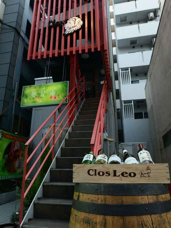 大きな樽とワインケース、赤い柵とライオンのマークが目印