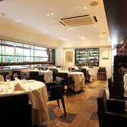 入口から一歩なかに足を踏み入れると、白と茶を基調とした上質な空間が広がります。右手はテラス席。窓からは自然光の差し込む店内で、緑を楽しみながら食事をすることができます。