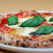 【グラッチャーノ】のピッツァは生地の薄い本格イタリアンタイプ。よく熱した石窯で短時間に焼き上げています。表面はパリパリ、まわりがほどよく膨らんだもっちりとした食感とチーズの味わいをぜひご堪能ください。