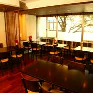 茶色の濃紺のインテリアでまとめ、落ち着いた雰囲気を演出。通りに面した大きな窓により開放感もあります。