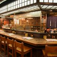 気さくな料理人の成田将さんが焼き物を仕上げる姿を目にしながら、ゆっくり料理とお酒でお寛ぎください。