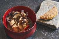 舞茸、松茸、昆布、セミドライのトマトを重ねるようにセルクルに差し込み、バターやオリーブオイルでじっくりと火入れ。そこに椎茸から取った滋味あふれるスープを掛けます。茸の軸を入れて揚げたパイを添えて。