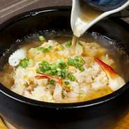 アツアツの石鍋に入ったエビ・イカ・貝などの炒飯に、中華風味のあんをジュッ！　目にも楽しいメニューです