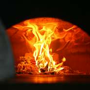 本場ナポリのピザの味を忠実につくりあげる料理人がこだわったものの一つ、イタリアから輸入した“薪窯”。本場ナポリの味を引き出すために欠かせない、重要な役割を果たしています。