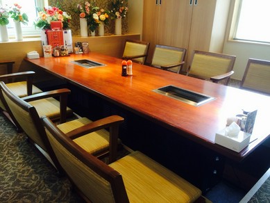 窓際にかわいい花が飾られた掘りごたつ式のくつろげる個室 