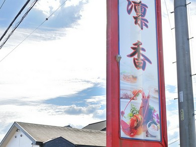 赤い大きな看板と広い駐車場が目印です