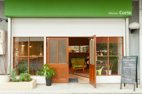 グリーンと木枠のドアが引き立つ、カフェのようなエントランス