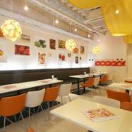 店内は白とオレンジが基調。壁にかけられたフルーツの写真が、明るく開放感に満ちた空間に彩りを加えます。友達との楽しいおしゃべりも盛り上がりそう。
