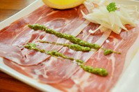 イタリア直送の生ハムをバジルソースが引き立てた一品