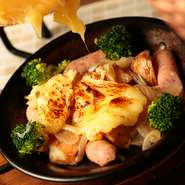 ラクレットというスイスのチーズを溶かし、じゃがいもやたまねぎなどの上にかけた、食べ応えのある一品。