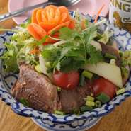 厚切りの牛肉のステーキは大満足の食べ応え。新鮮な何種類もの野菜、酸味と香りが食欲をそそります。
