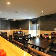 黒を基調にした壁と、明るい木の色が調和したシンプルな内装に、ダークブラウンのテーブルが配置されていて、店内はしっとりと落ち着いた印象。年齢層や年代を問わず、利用しやすい雰囲気です。