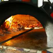 有田焼の窯元に依頼してつくられた新窯。カラフルなタイルは、店主が一枚一枚ていねいに貼り付けたものだとか。注文を受けてから焼き上げられるピッツァは、生地の旨みがしっかりと感じられる逸品です。